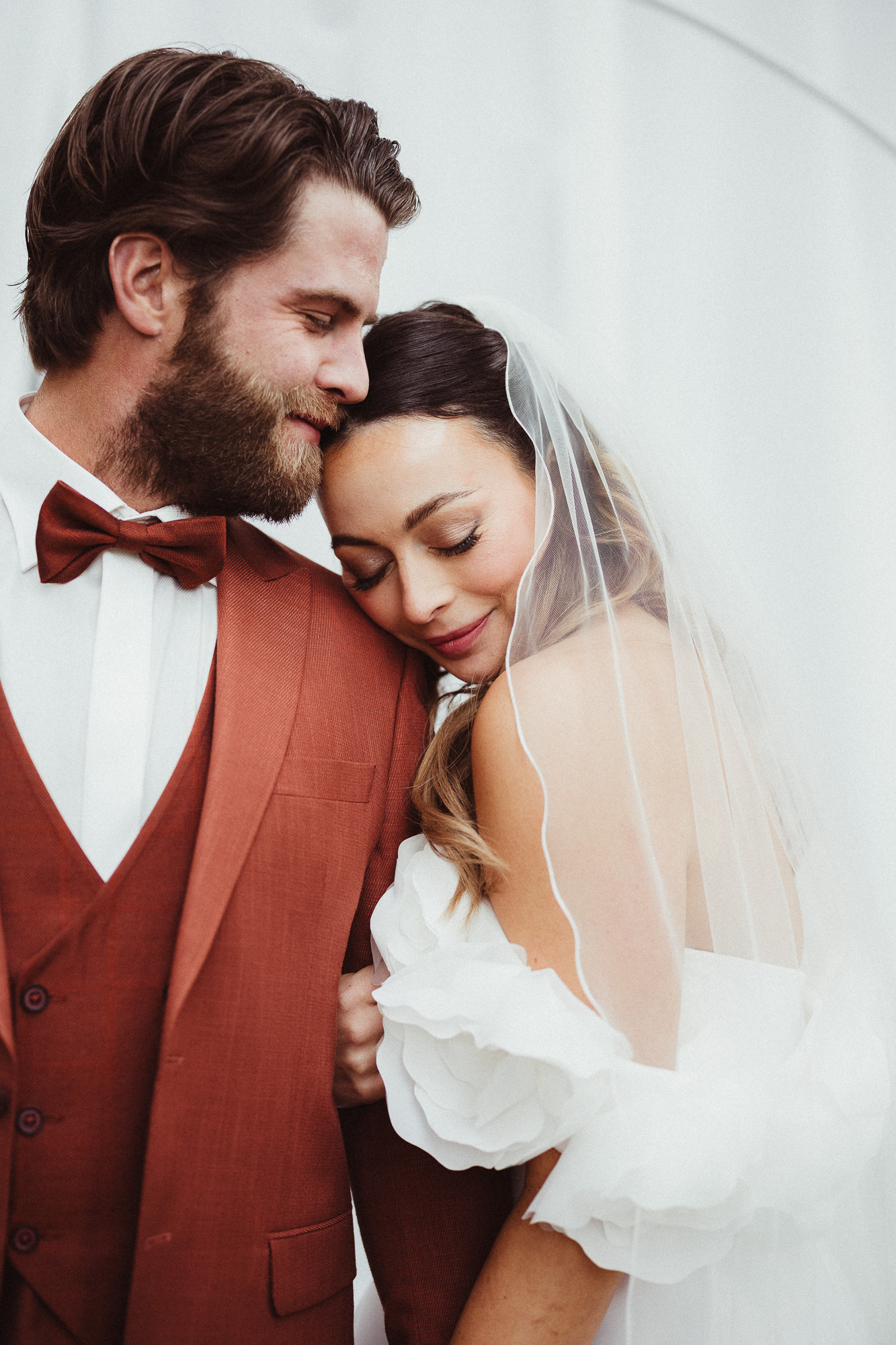 Braut schmiegt sich eng an Bräutigam