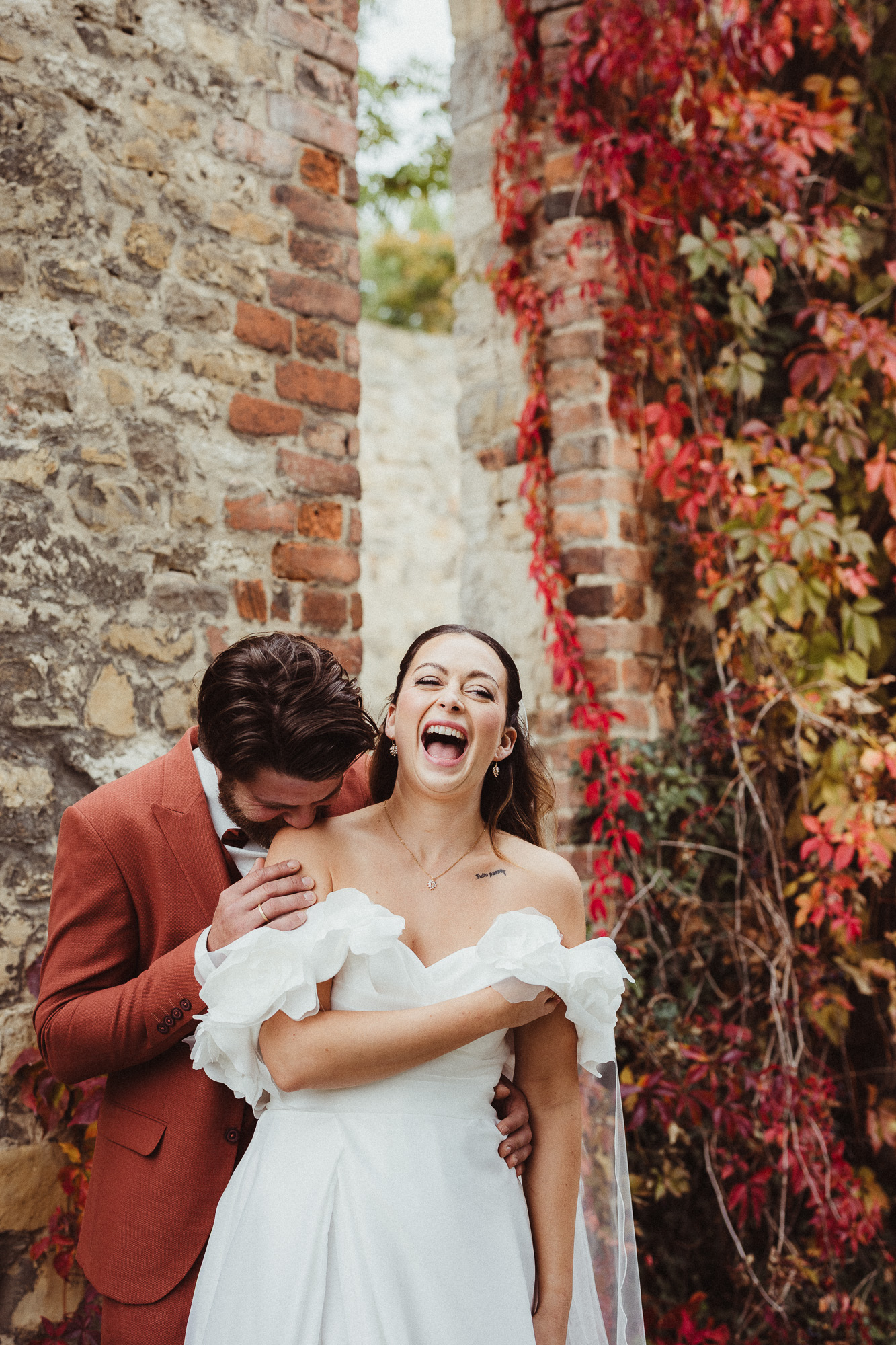 Brautpaar lacht beim Küssen